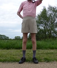 Pink shirt, girly shorts and tan open body tights in the park