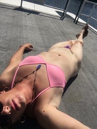 Suntanning in my pretty pink clitty cage and matching bikini top!