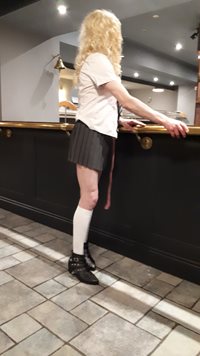 naughty school girl standing at a bar