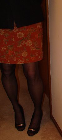 Orange skirt and sheer black hose and heels.